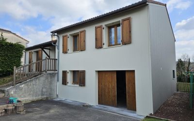 Isolation par l'extérieur d'une maison à Naucelles dans le Cantal par l'équipe d'Ecothermic avec des panneaux finition crépi CRAIE BLANCHE pour la façade avant et BASALTE pour le côté pignon.