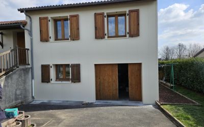 Isolation par l'extérieur d'une maison à Naucelles dans le Cantal par l'équipe d'Ecothermic avec des panneaux finition crépi CRAIE BLANCHE pour la façade avant et BASALTE pour le côté pignon.